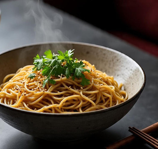 Steaming bowl of Tasty Jowar Noodles with green herbs and sesame seeds on it.